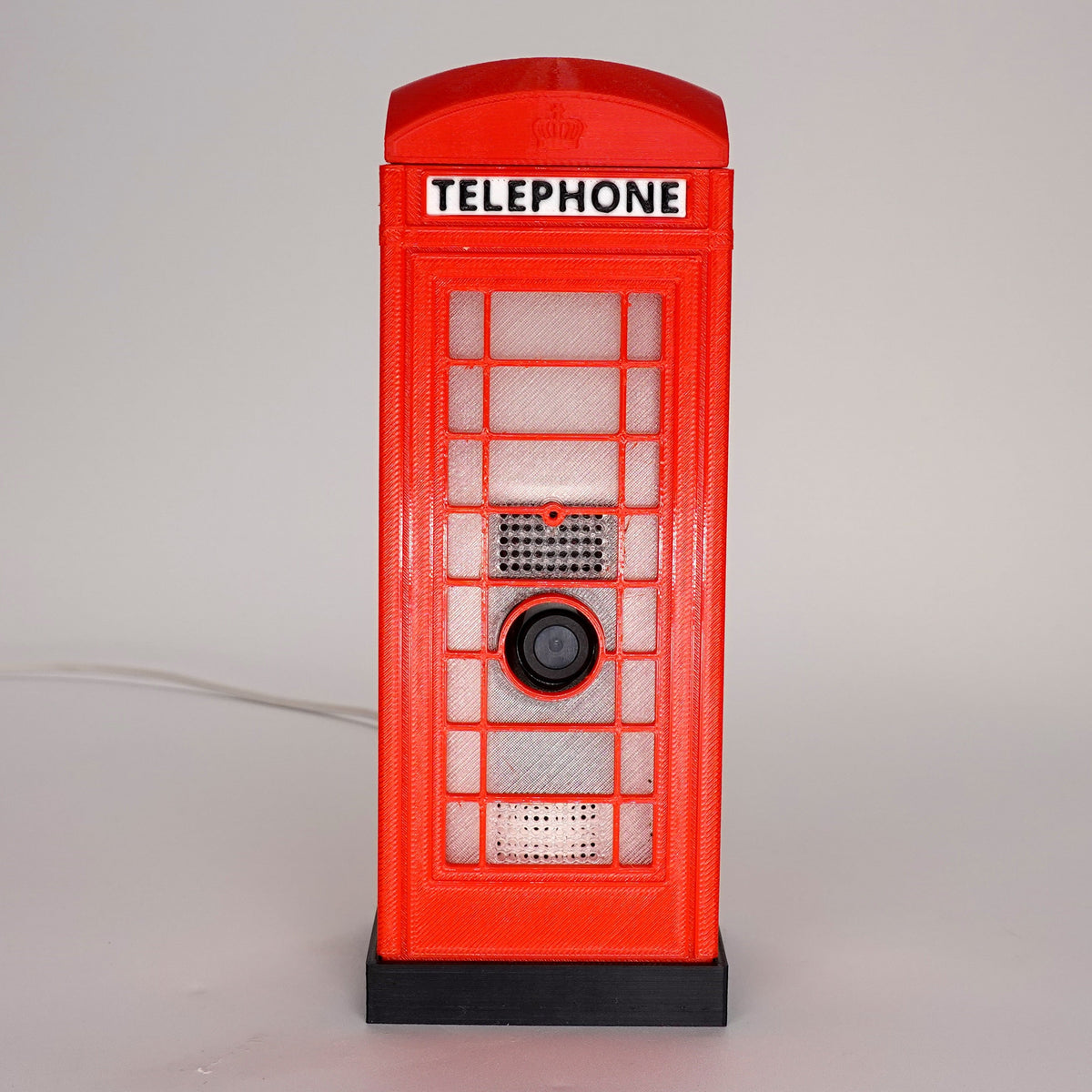 Front-facing view of a 3D-printed red London K6 phone booth case with a Ring Indoor Cam Gen 2.